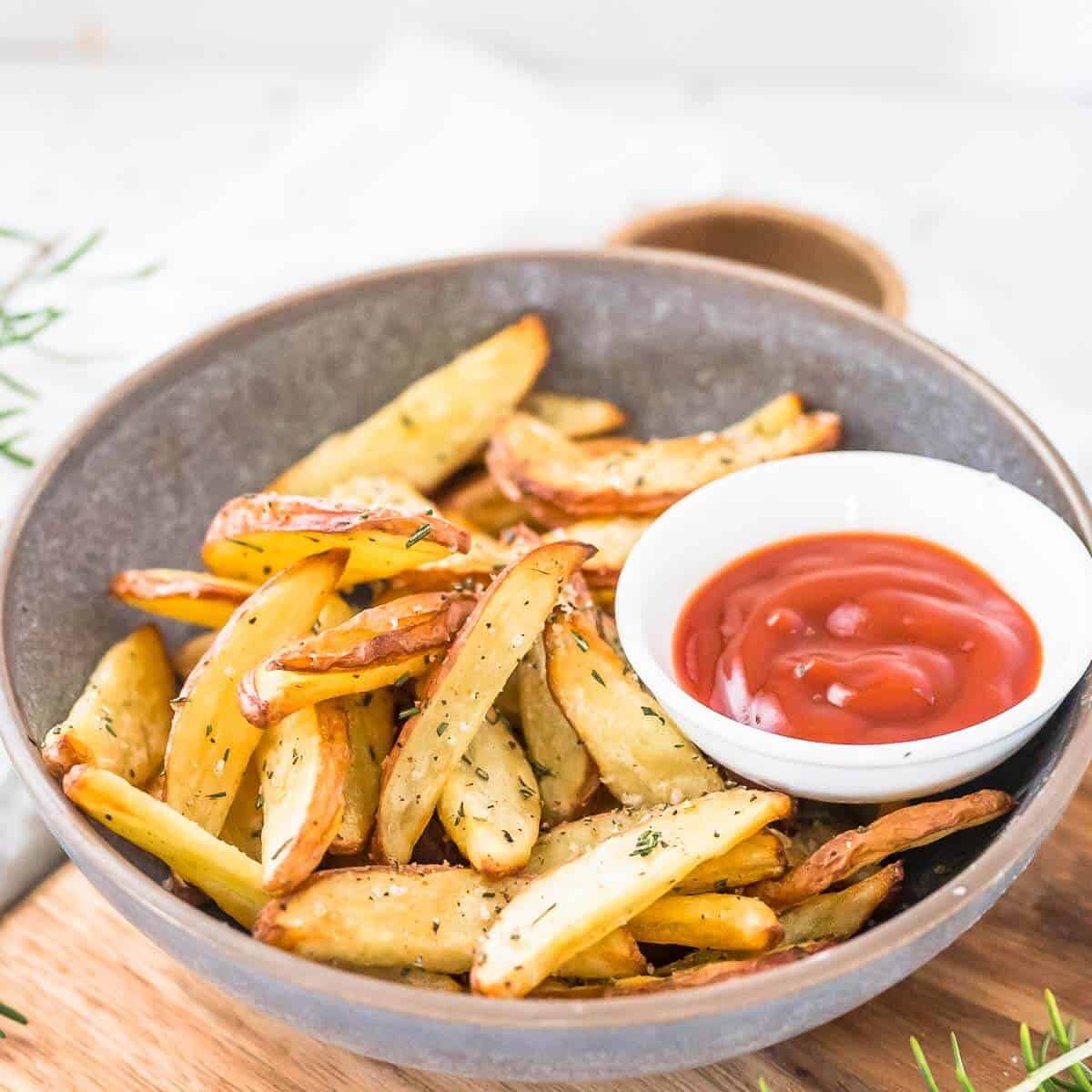 grey bowl with air fried potato wedges and ketchup