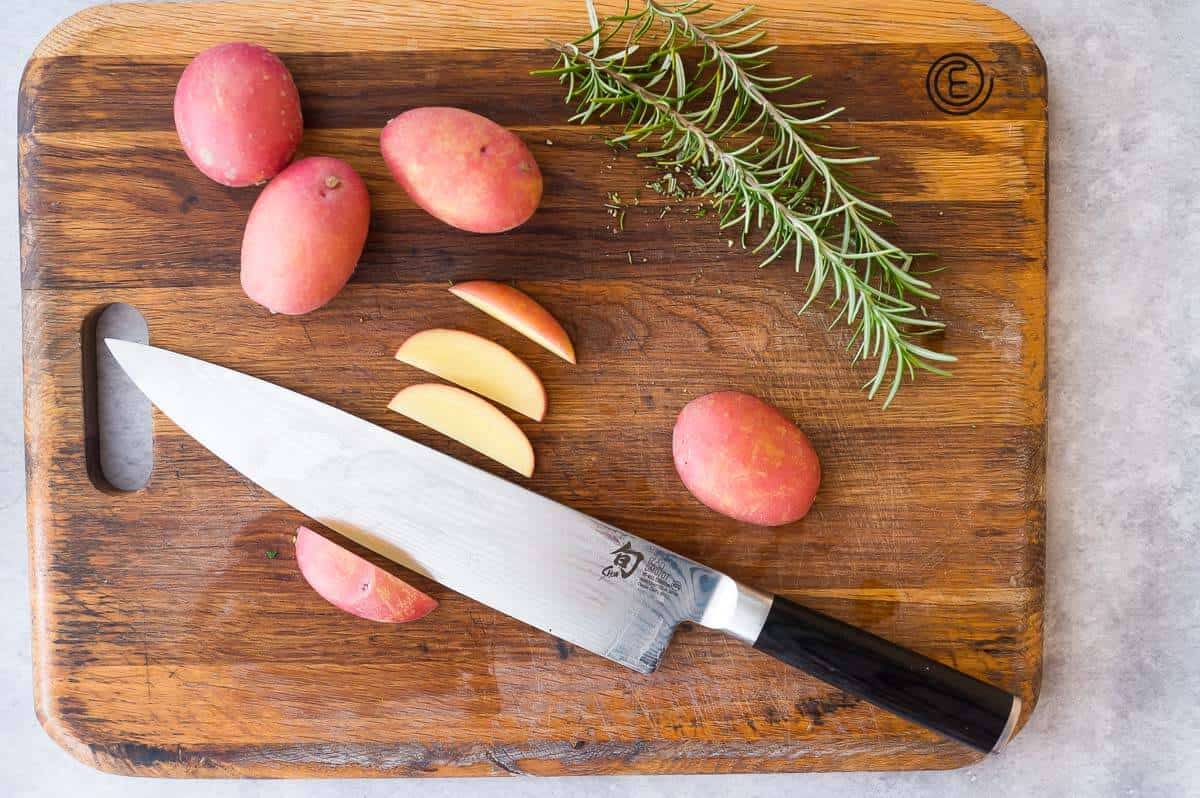 cutting potatoes into wedges on a cutting board