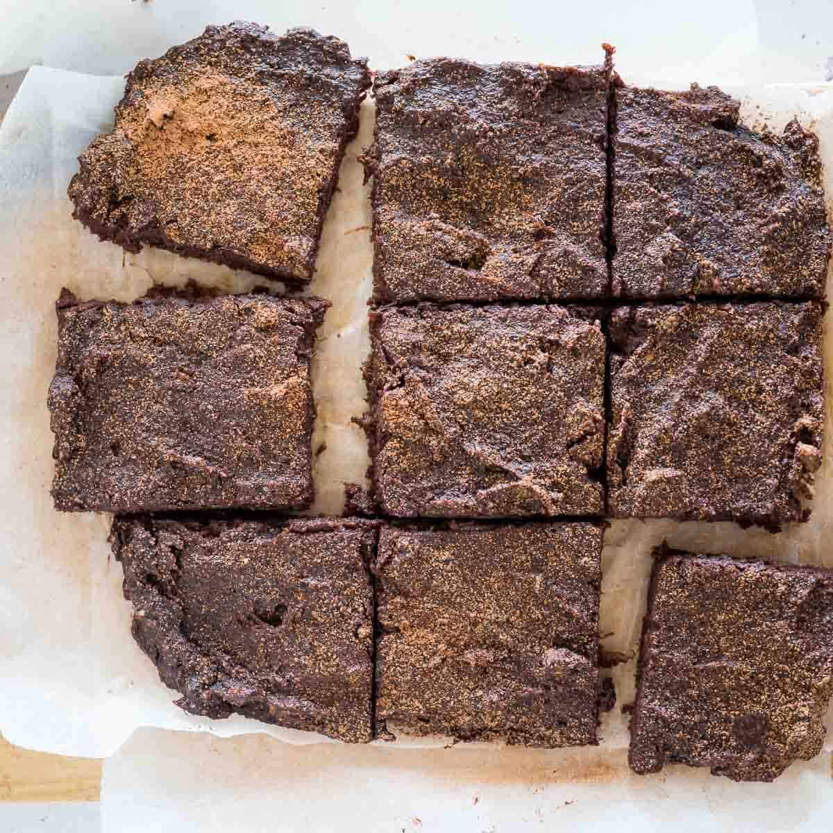cooked brownies chopped into 9 pieces on a board
