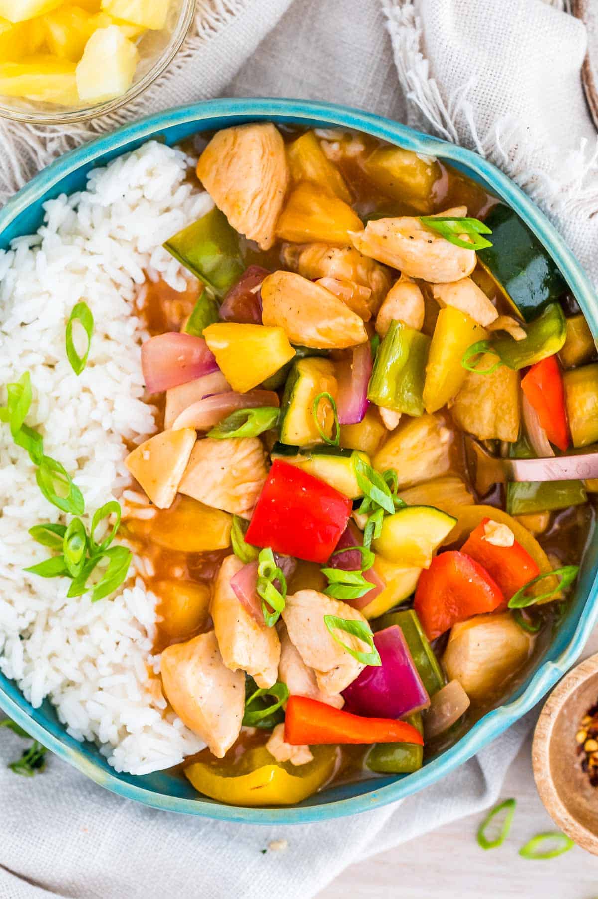 a bowl of sweet and sour chicken with pineapple and rice