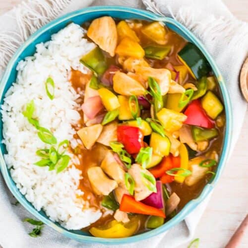 a blue bowl of sweet and sour chicken and rice