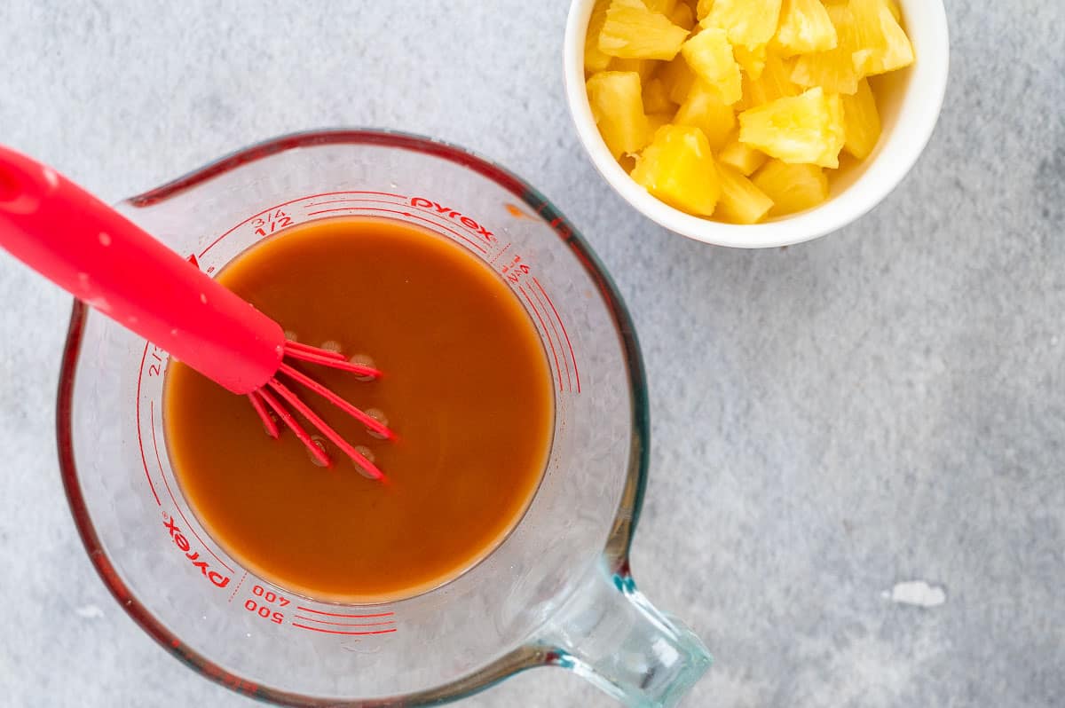 sweet and sour sauce ingredients in a jug with whisk