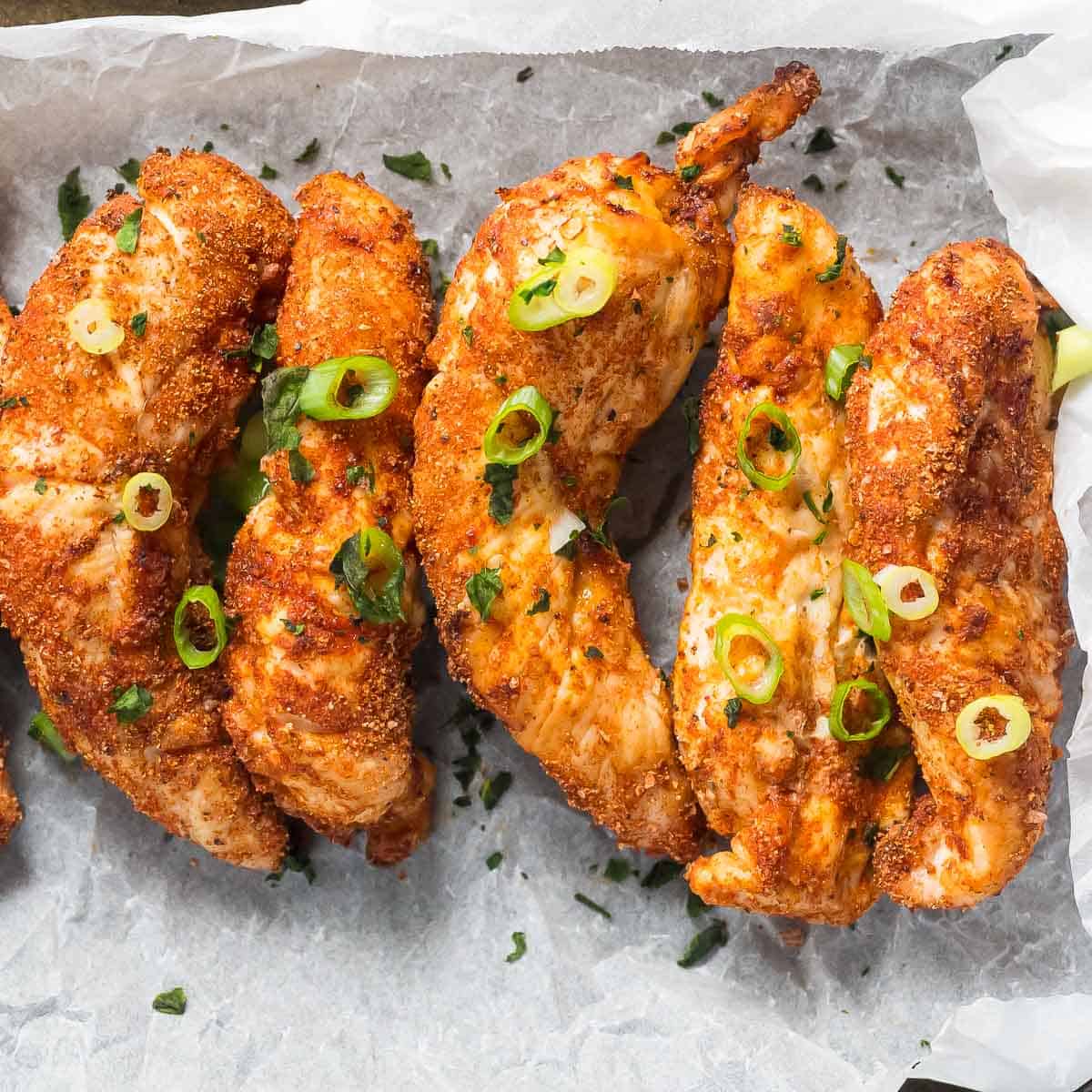 5 air fryer chicken tenders laying on baking paper