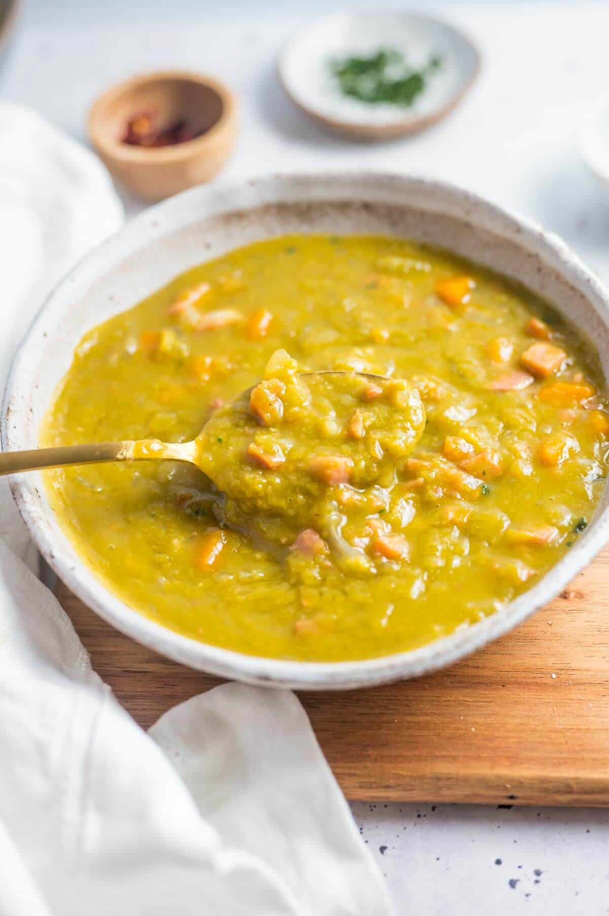 a spoon in a bowlful of splitpea and bacon soup