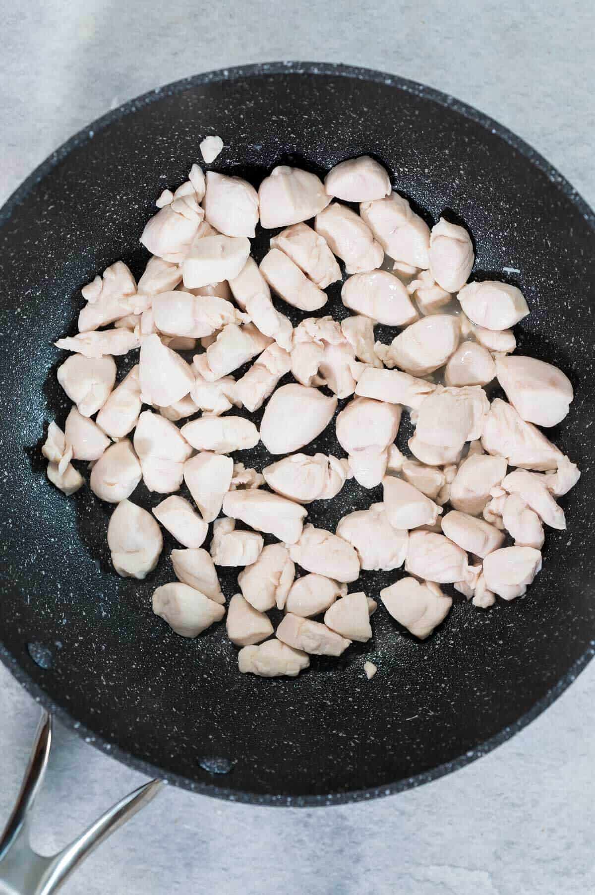 cooking chicken breast pieces in a pan