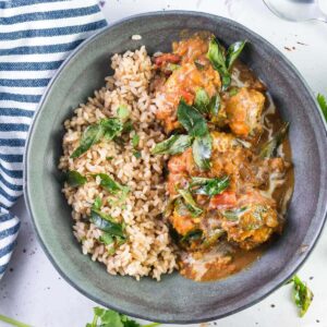grey bowl with butter chicken meatballs and rice