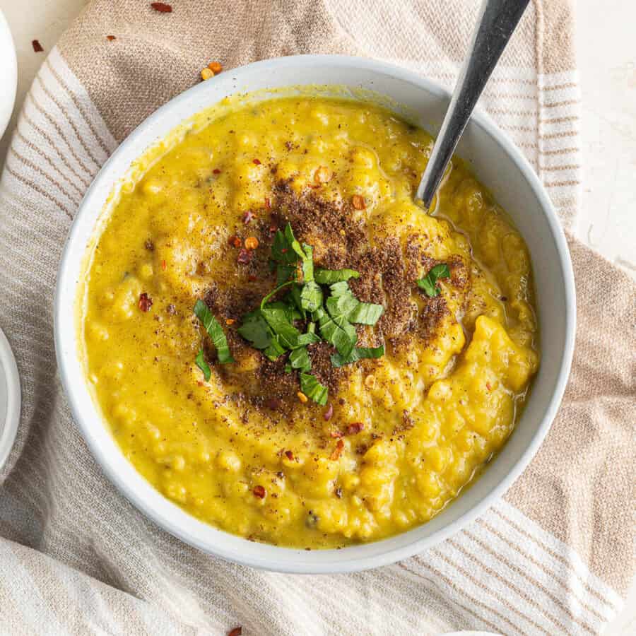 a bowl of yellow split soup with garnish