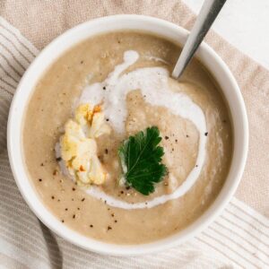 bowl of cauliflower soup with cream swirl