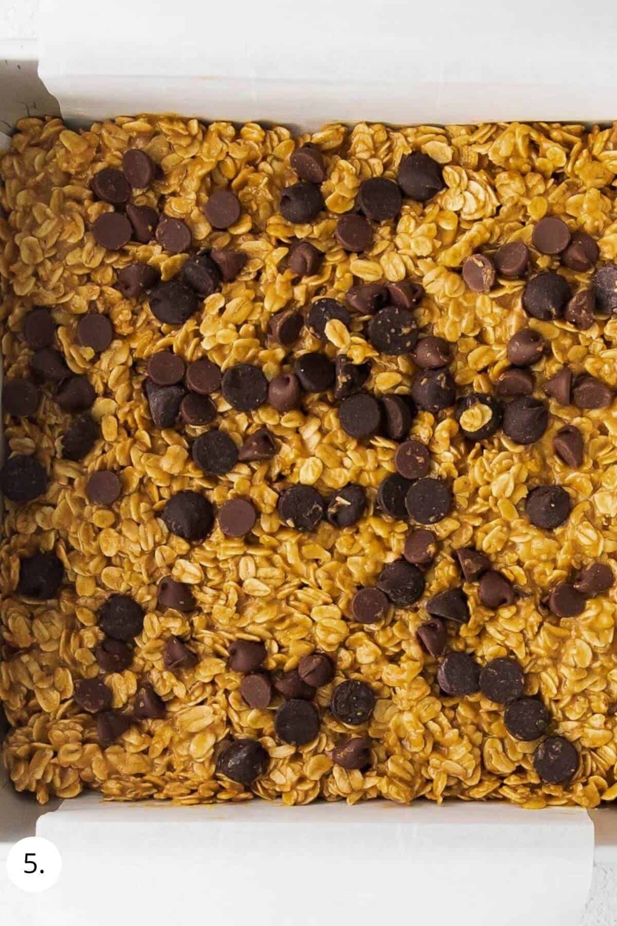 granola bar mixture in a pan with chocolate chips