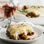 a serving of lentil shepherds pie on a white plate