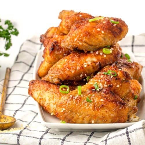 a stack of chicken wings on a white plate