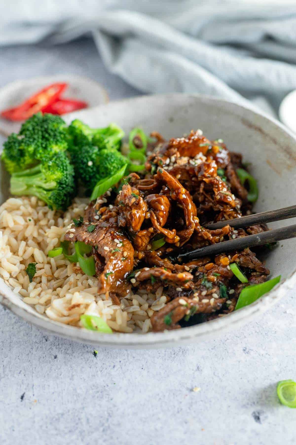 beef in garlic sauce in a bowl with chopsticks