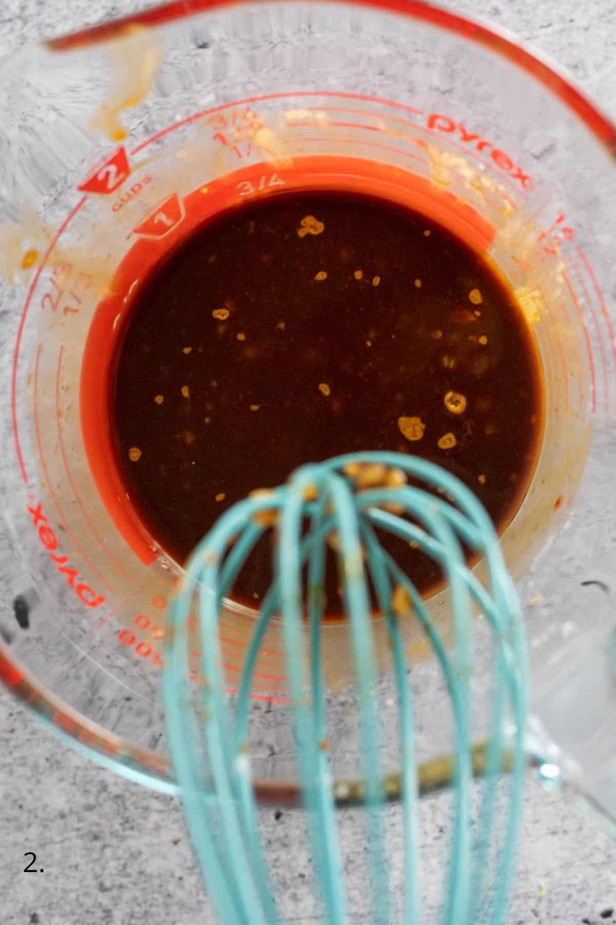 whisking garlic sauce in a jug