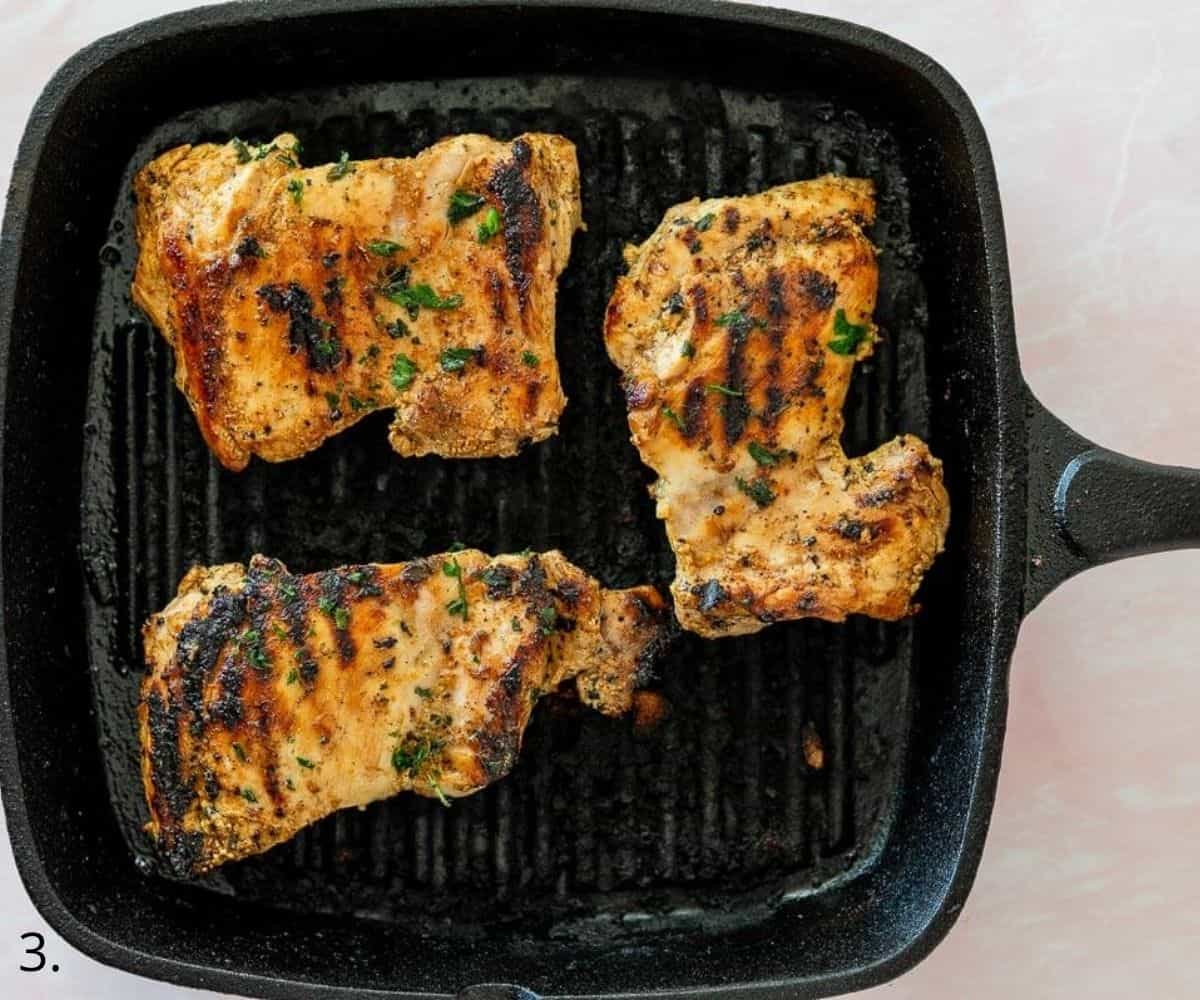 chicken thighs cooking in a skillet