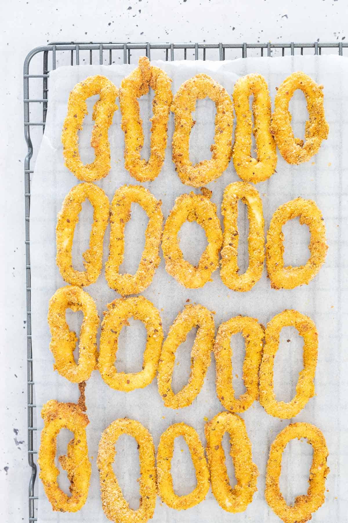 cooked calamari rings on parchment paper wire rack