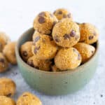 green ceramic bowl stacked with pumpkin choc chip energy balls