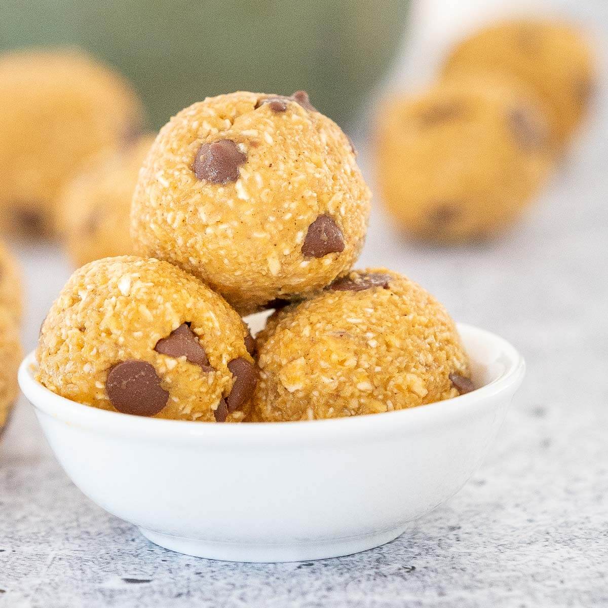 three pumpkin energy balls in a white bowl