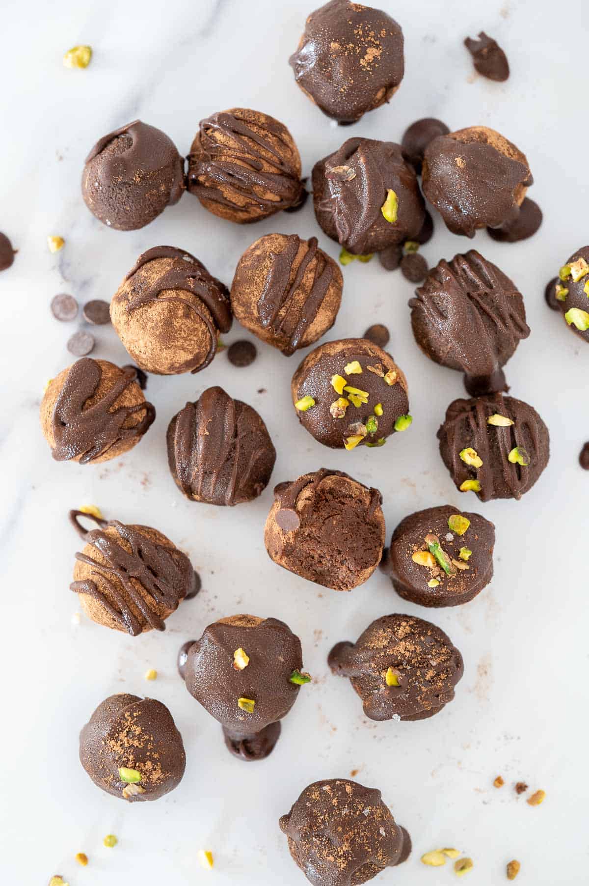 lots of chocolate avocado truffles scattered on a benchtop