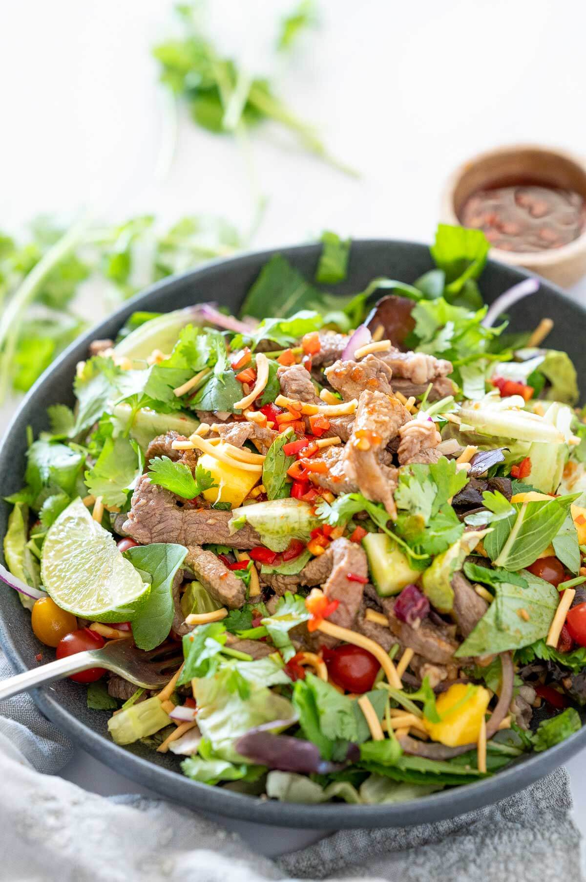 grey bowl with fresh thai salad and beef strips