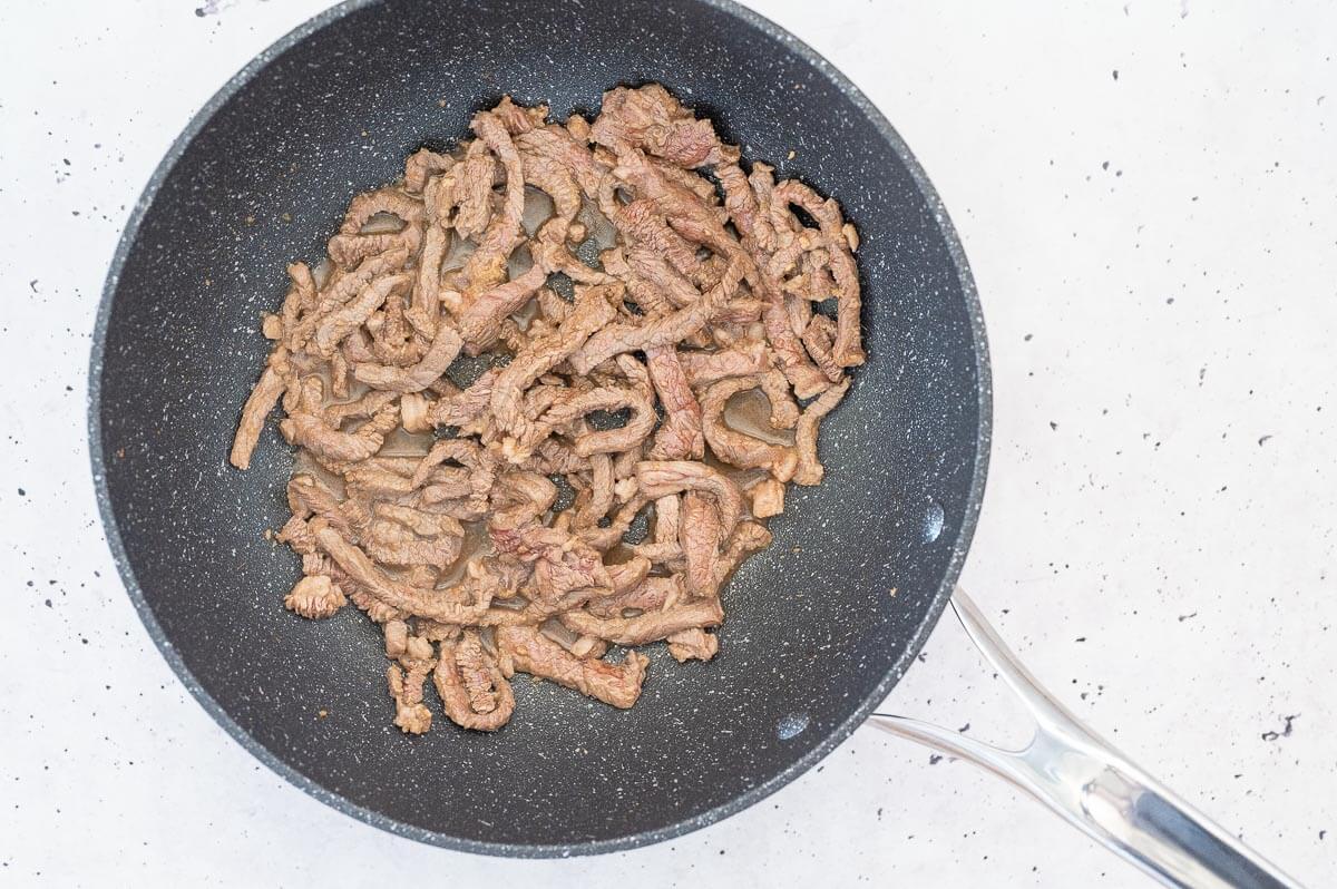 steak strips cooking in a wok