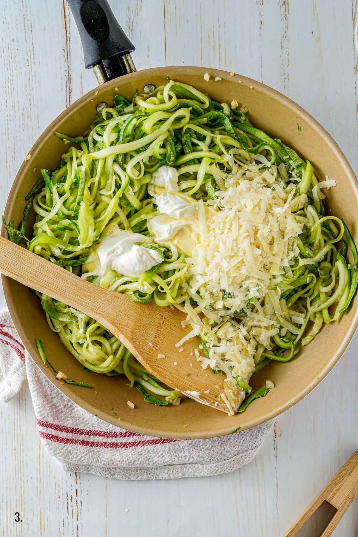 adding parmesan and butter to zucchini noodles