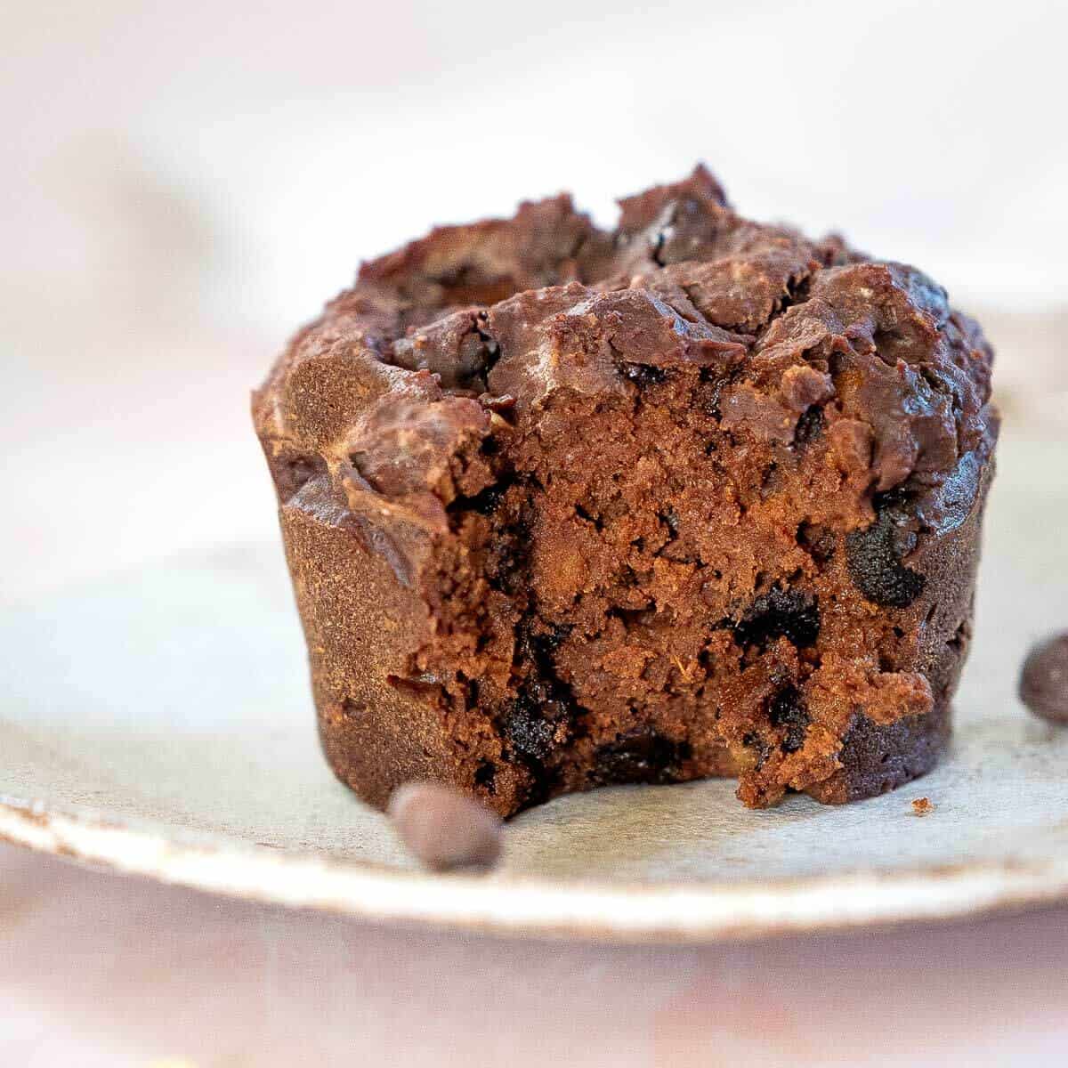 a single sweet potato muffin on a plate with a bite out