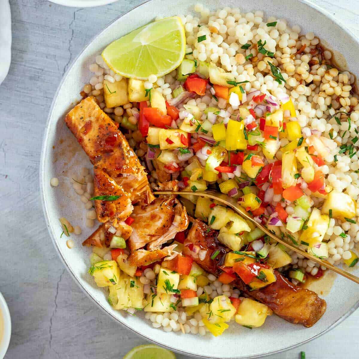 fork in a bowl of salmon with pineapple salsa