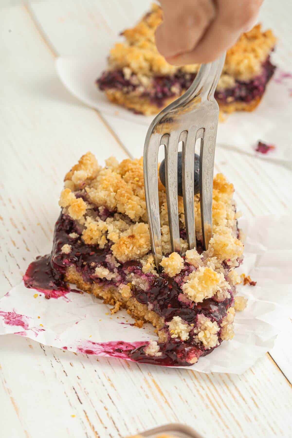 fork digging into berry crumb bar