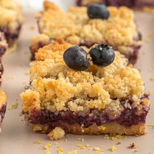 a single blueberry and lemon crumb bar on a board