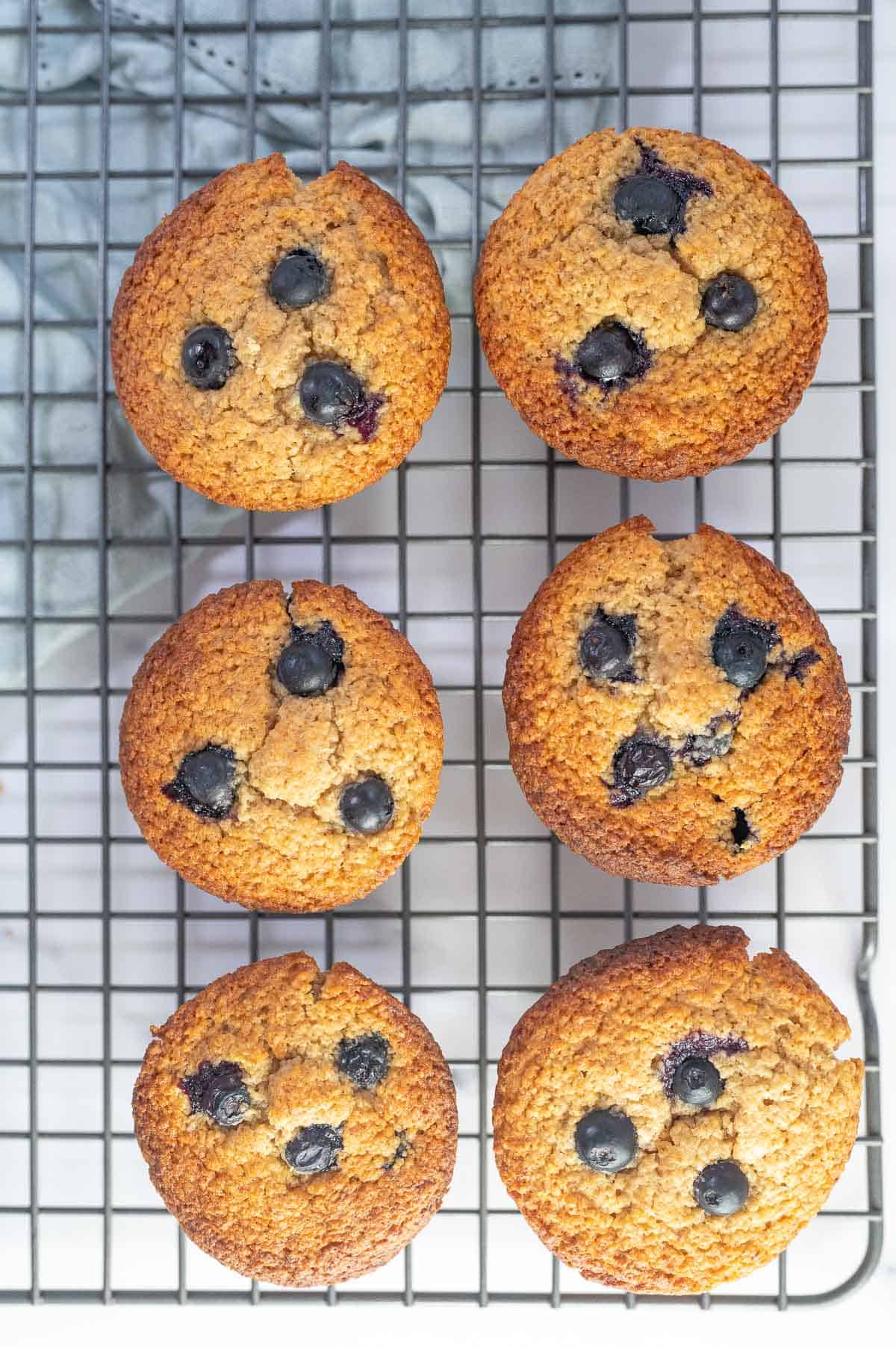 6 blueberry muffins on a wire rack