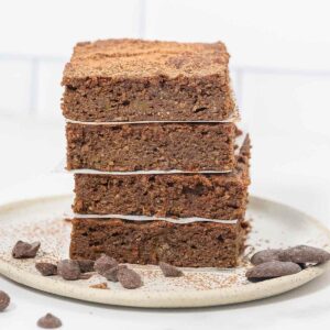 a stack of 4 pumpkin brownies on a plate with chocolate chips