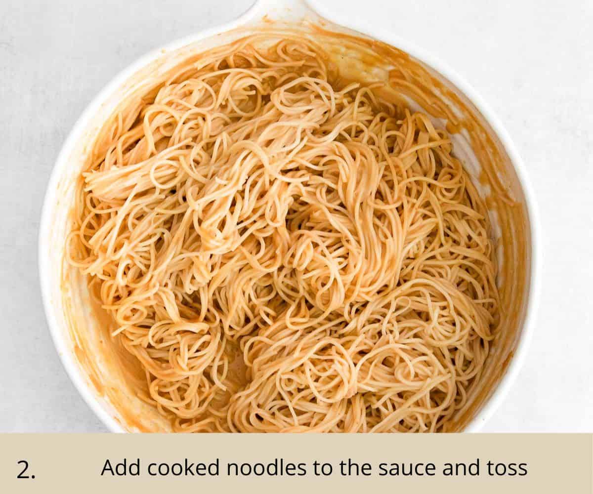 Noodles tossed in a bowl of peanut butter sauce