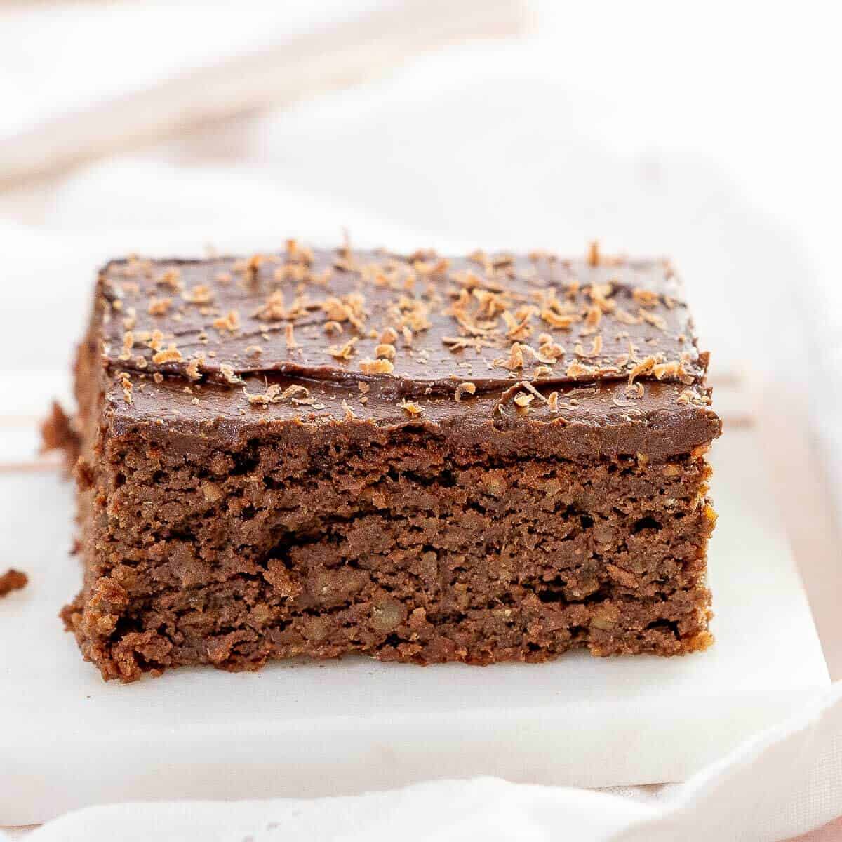 a slice of chickpea cake with frosting on a serving plate