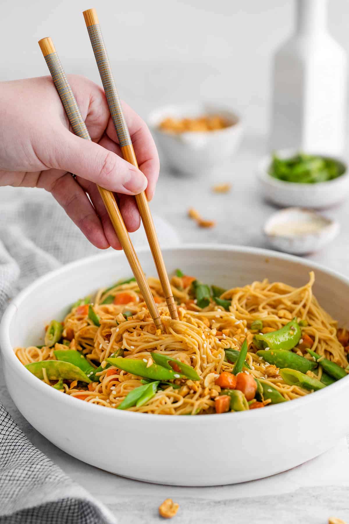 a boel of spicy peanut noodles with chopsticks dug in