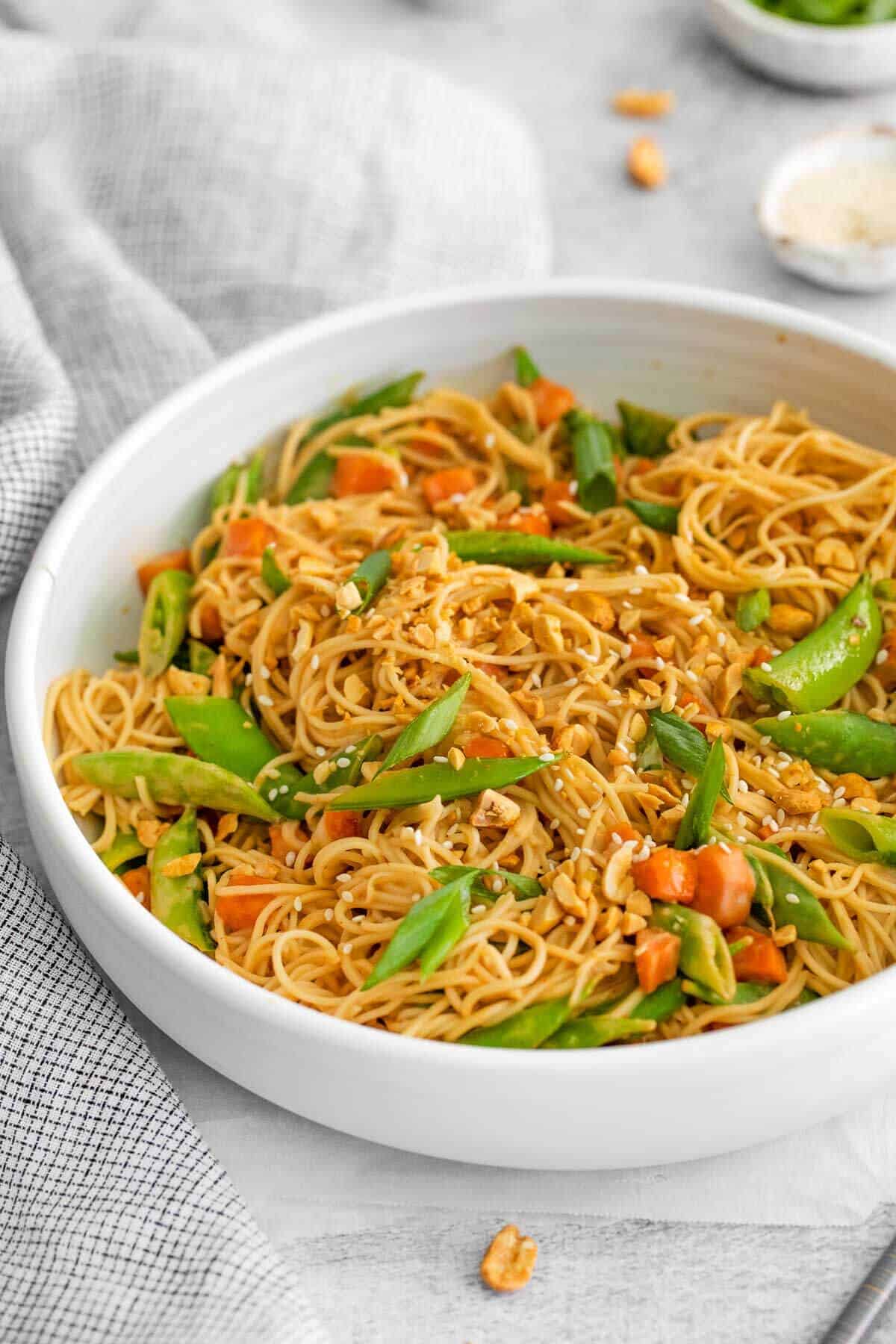 a big bowl of spicy peanut butter sauce noodles with vegetables