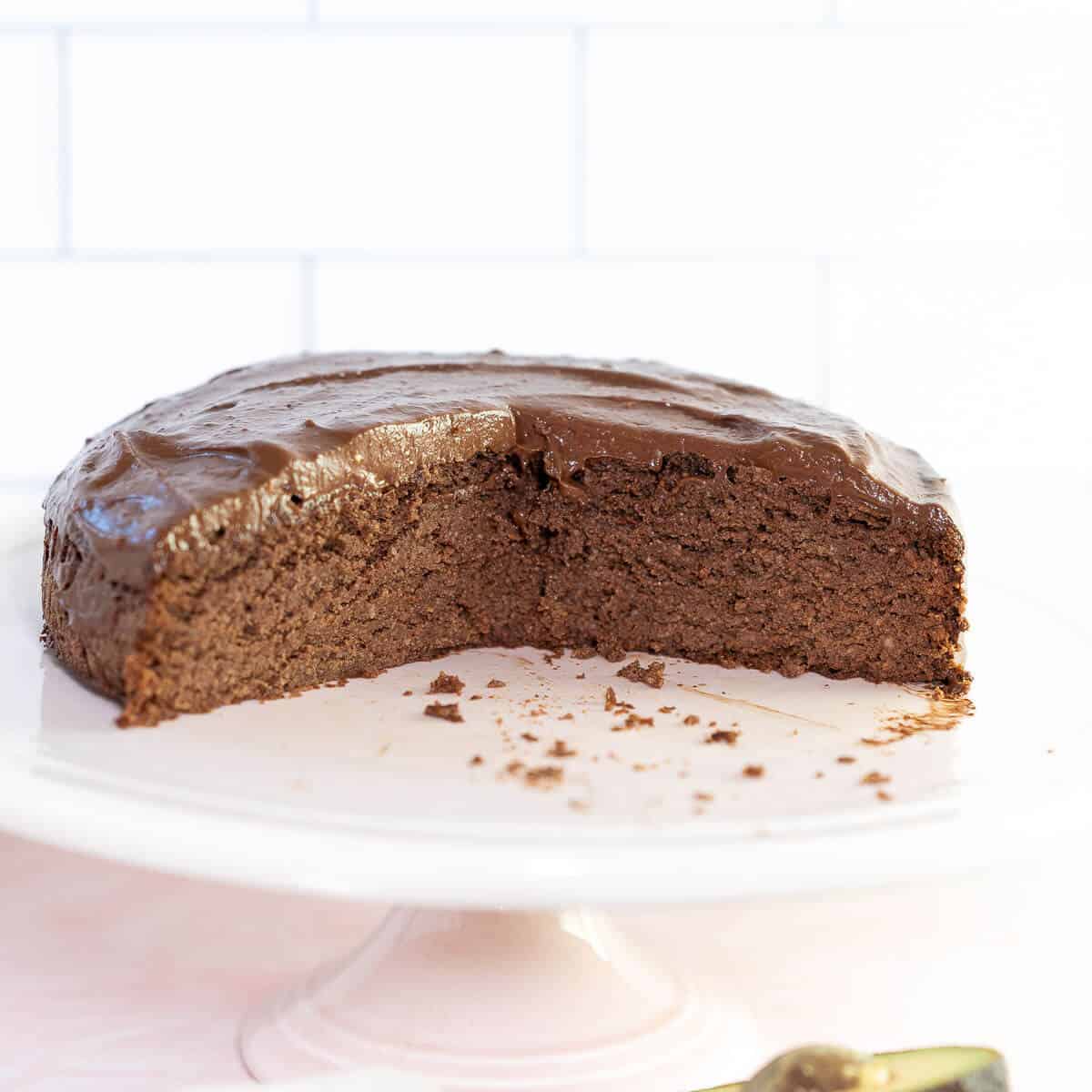 chocolate avocado cake with frosting on a serving plate