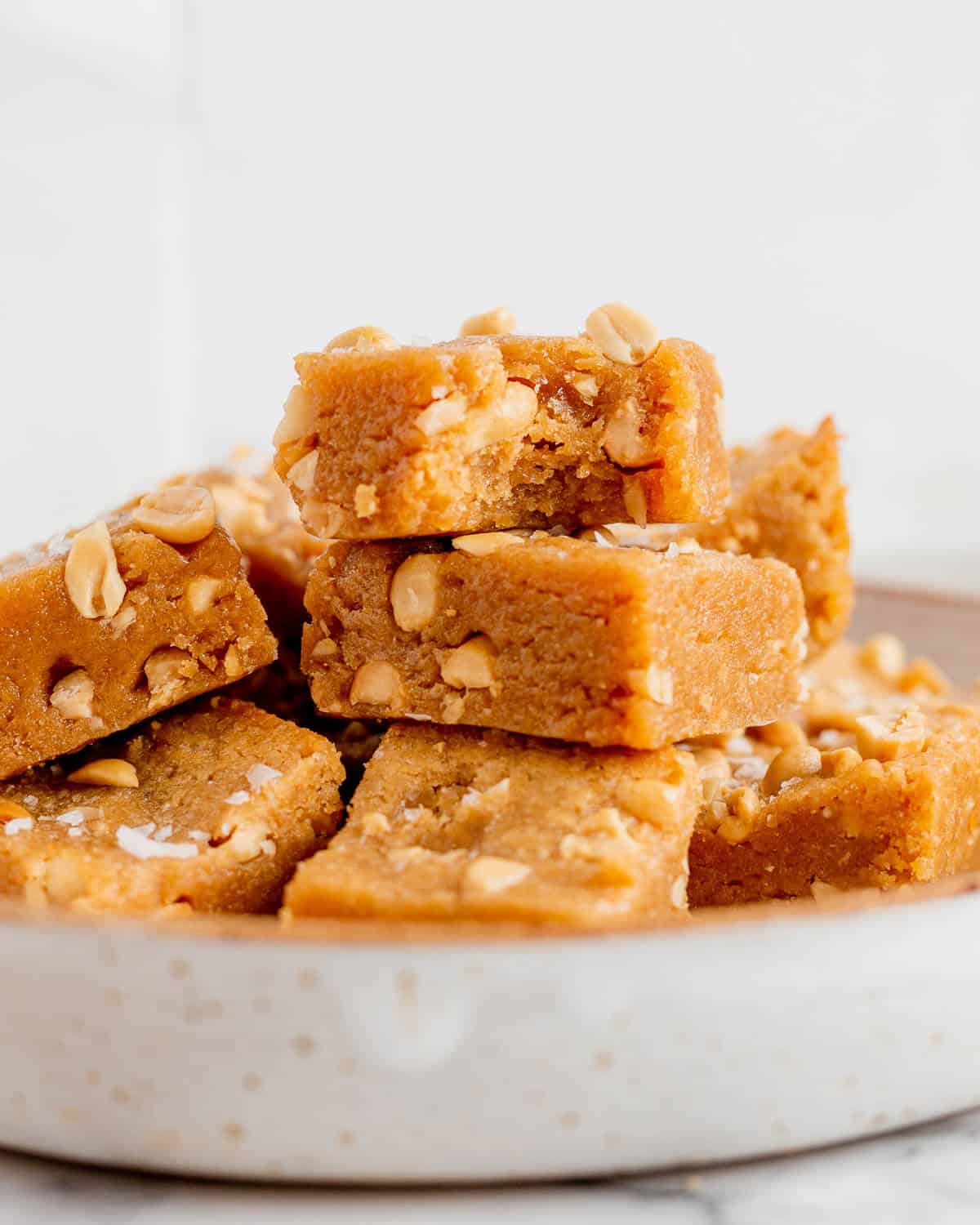 close up stack of peanut butter blondies in a bowl