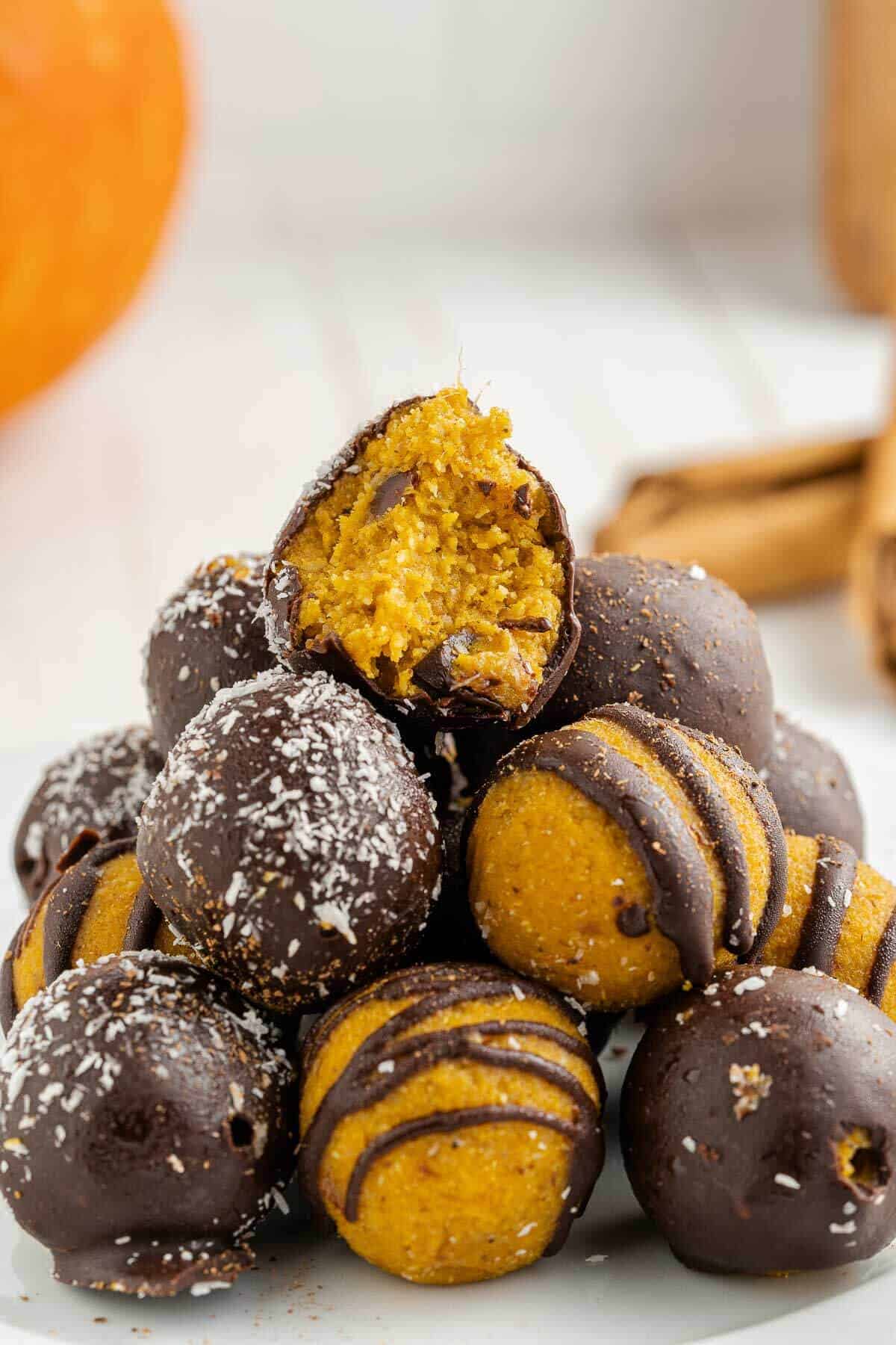 a stack of pumpkin truffles and top one has bite out