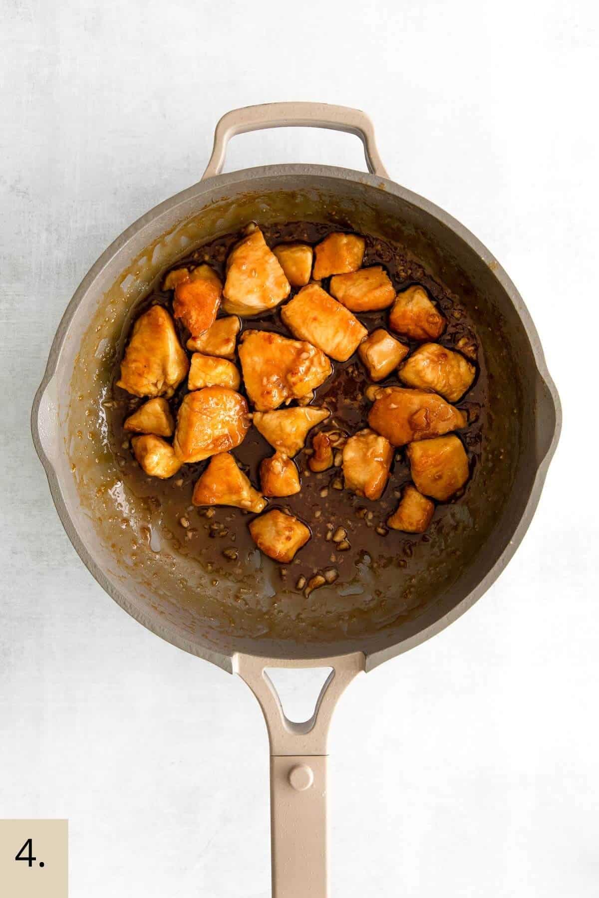 chicken pieces in a wok with honey soy garlic sauce