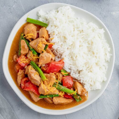 Chinese orange chicken with rice on a white plate