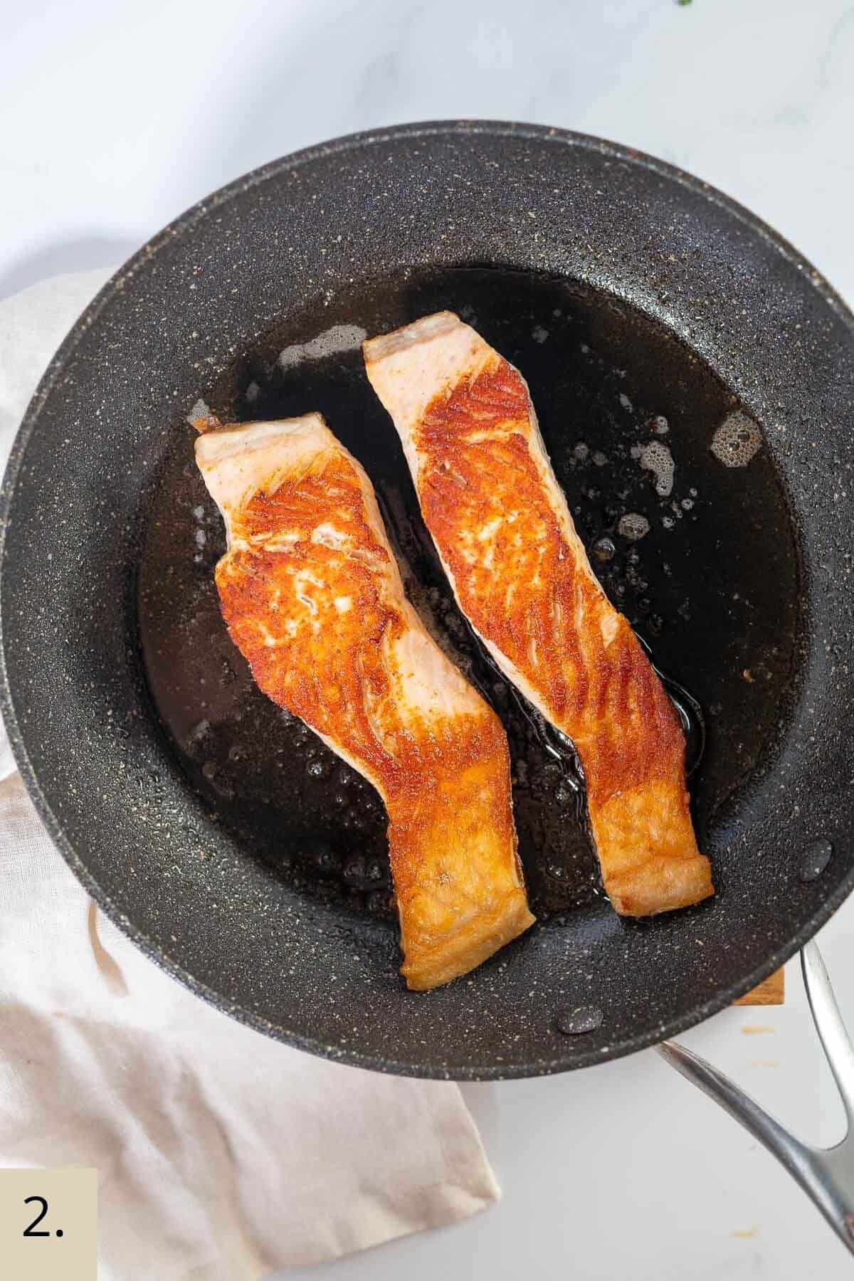 salmon cooking in a skillet