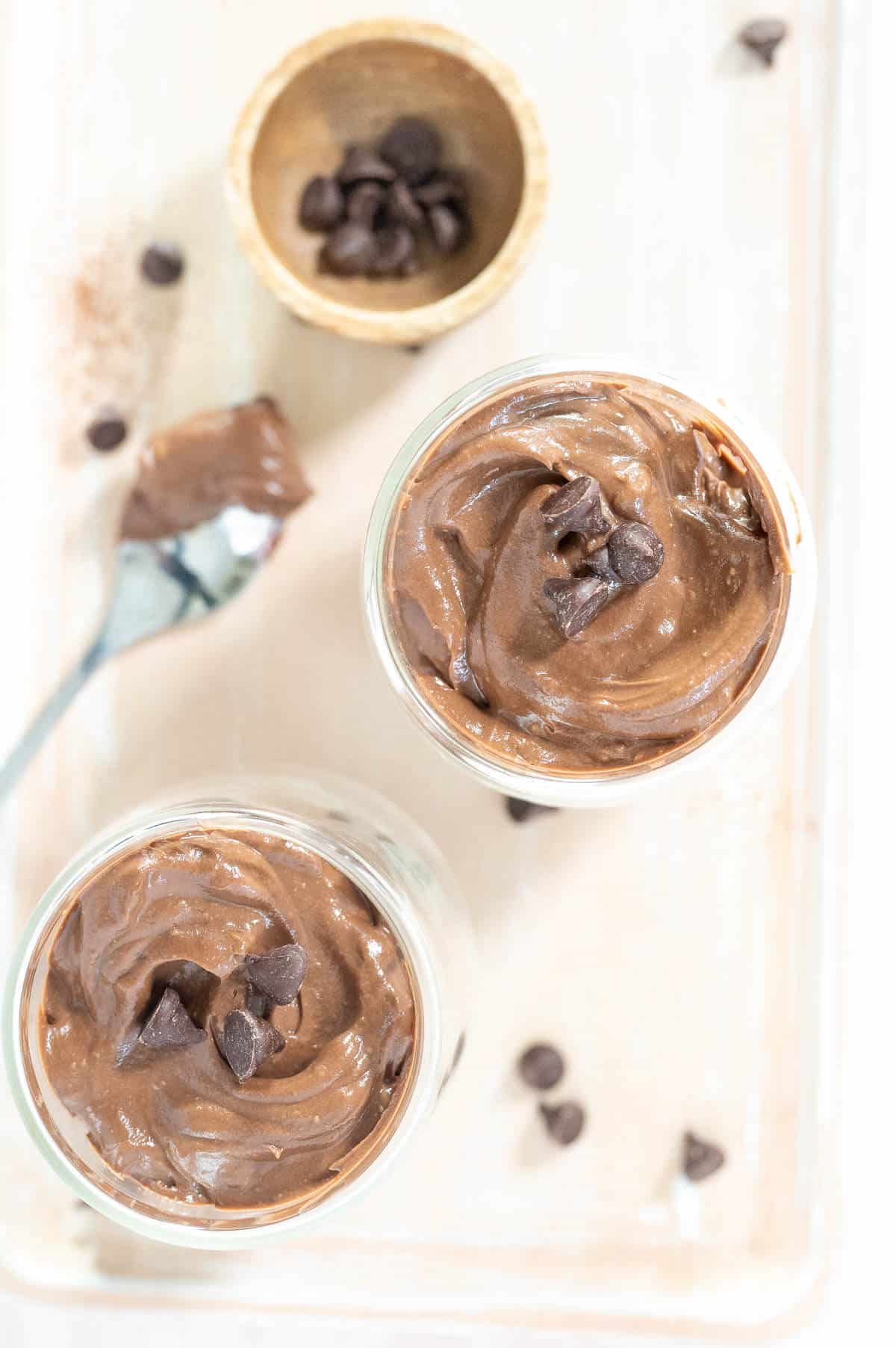 overhead photo of 2 cups of chocolate pudding with chocolate chips