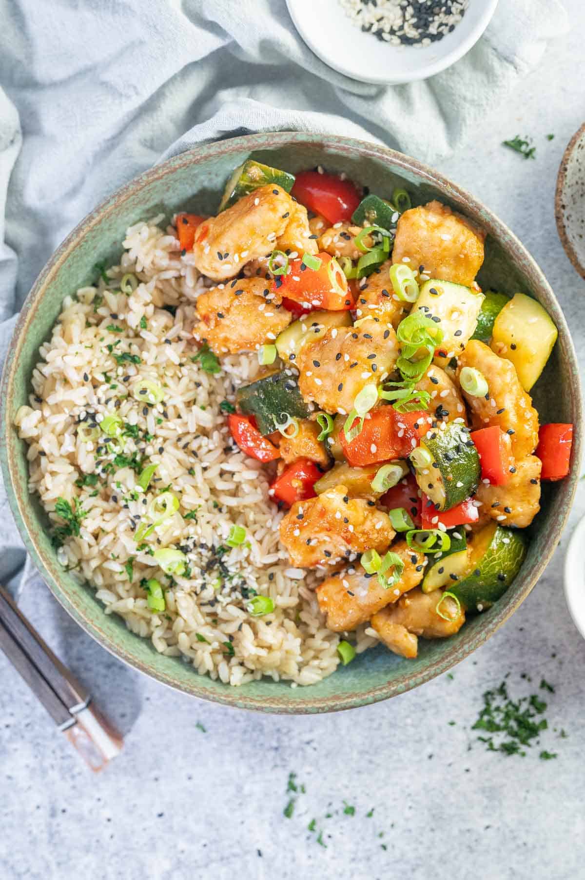 sweet chilli chicken with sesame seeds and green onions scattered on top