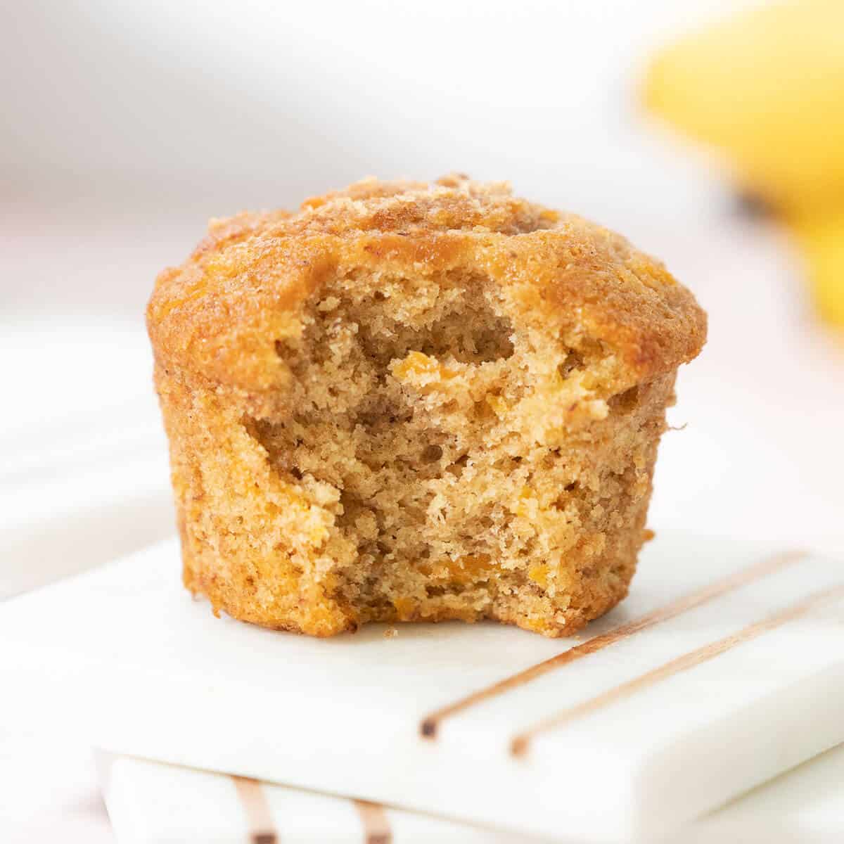 A single banana carrot muffin with a bite out