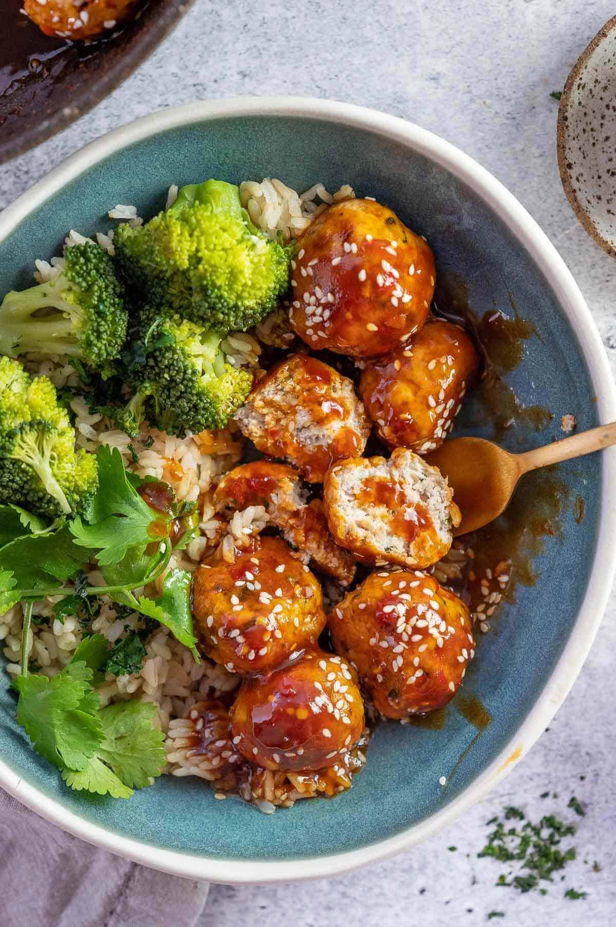 chicken meatballs in a bowl with sauce and fork