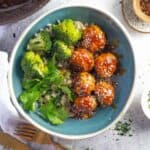 6 chicken meatballs in a bowl with rice and broccoli
