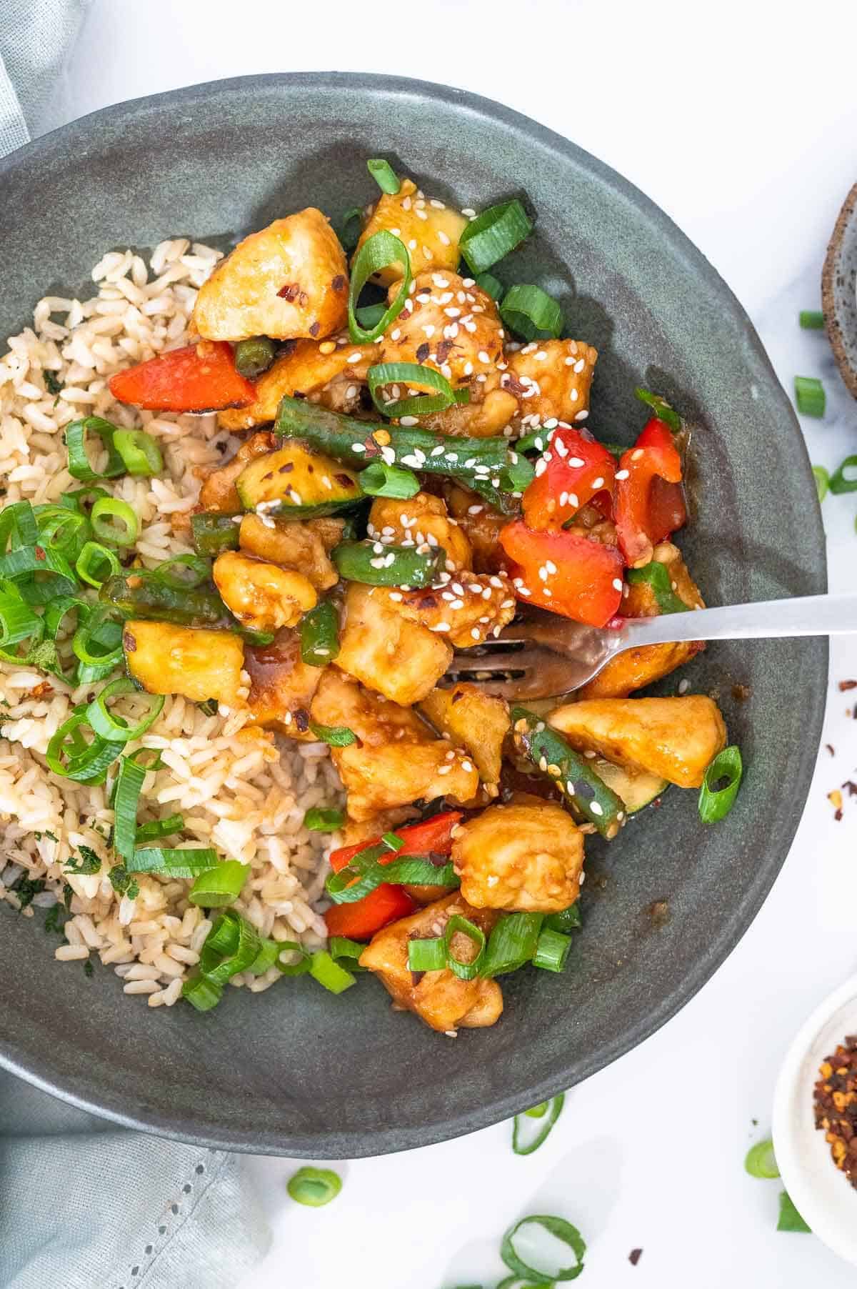 fork stuck in a bowl of mongolian chicken