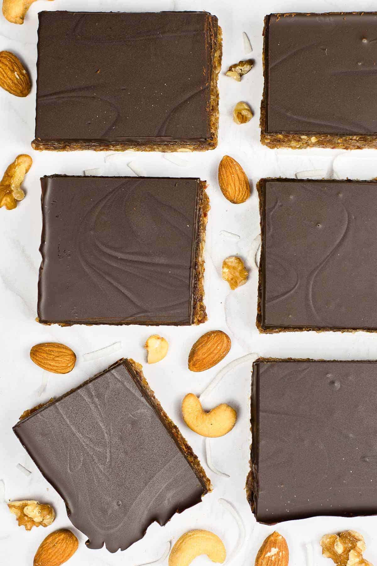 overhead shot of date and nut bars on a board with scatter nuts