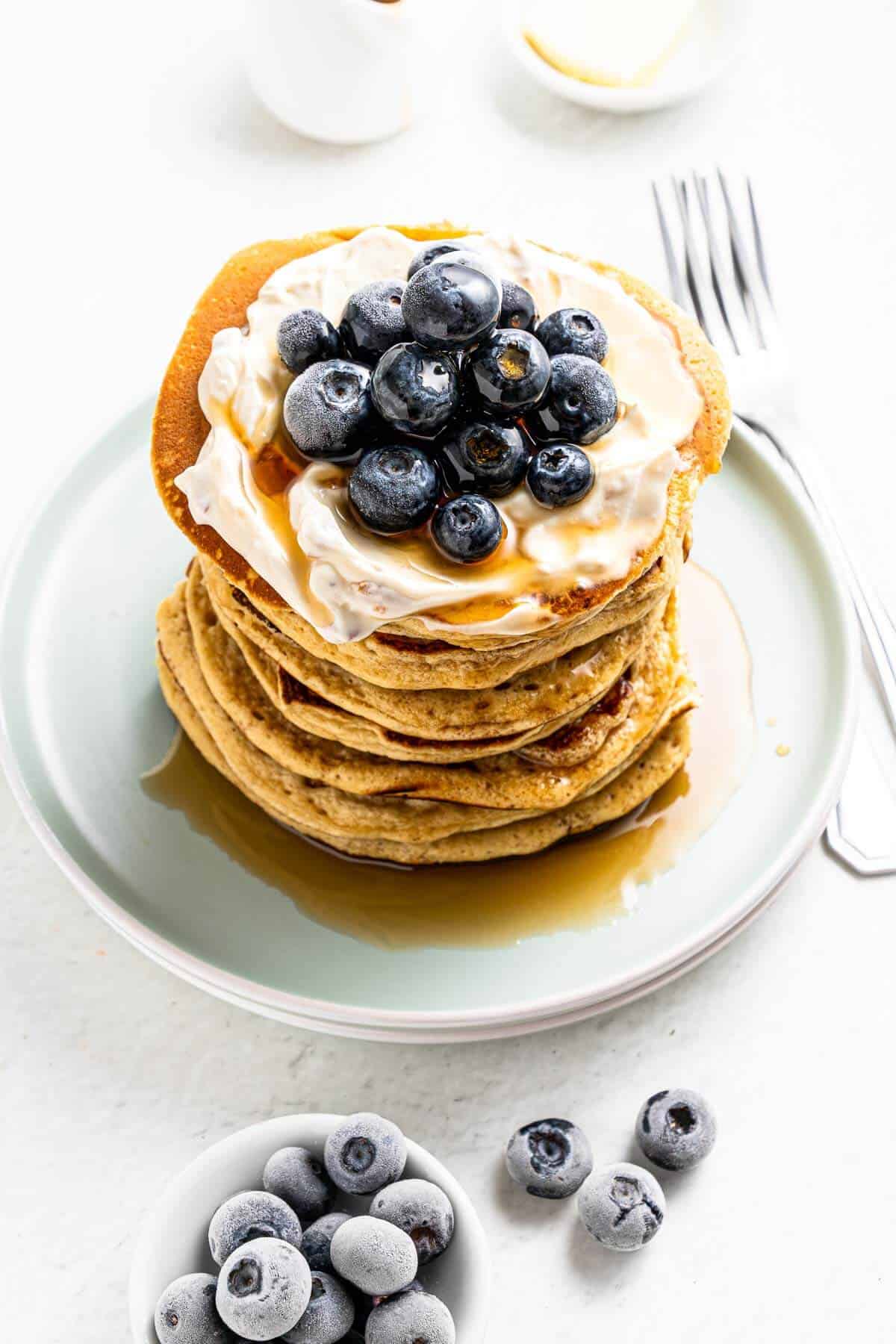 pancakes with protein powder and blueberries stacked on a plate