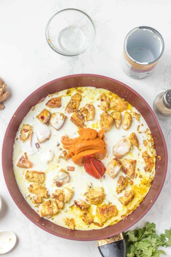 chicken, curry and coconut milk cooking in a skillet